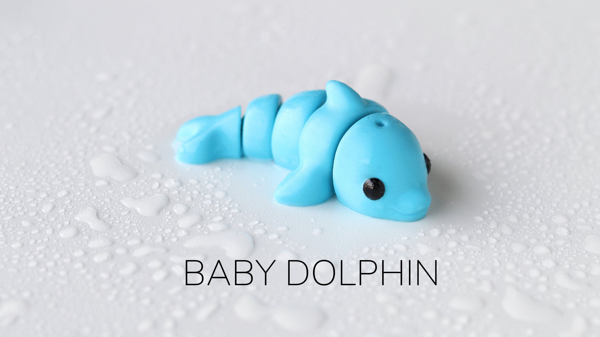 a baby dolphin toy laying on top of a white surface