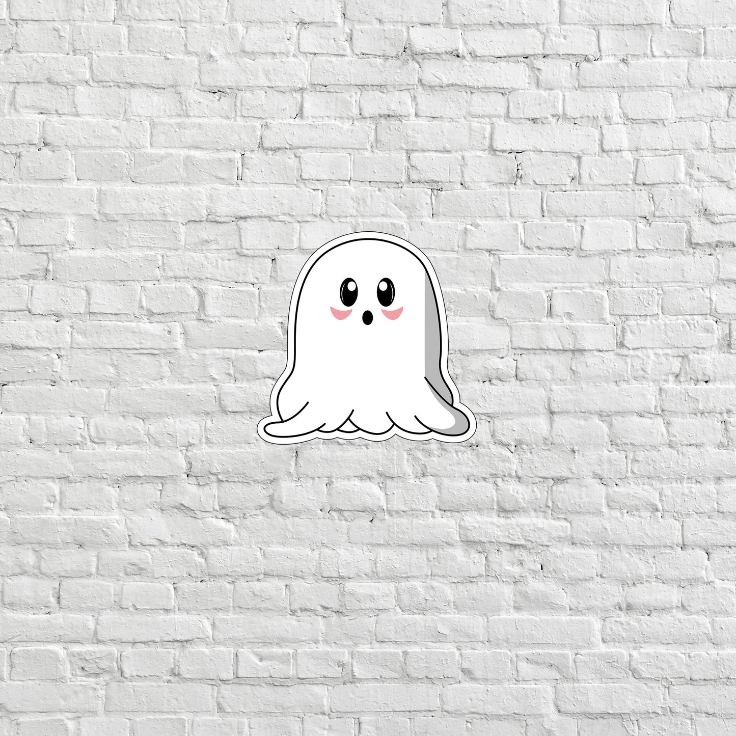 a sticker of a ghost on a white brick wall