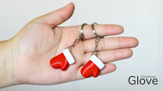 a hand holding a pair of red and white earrings