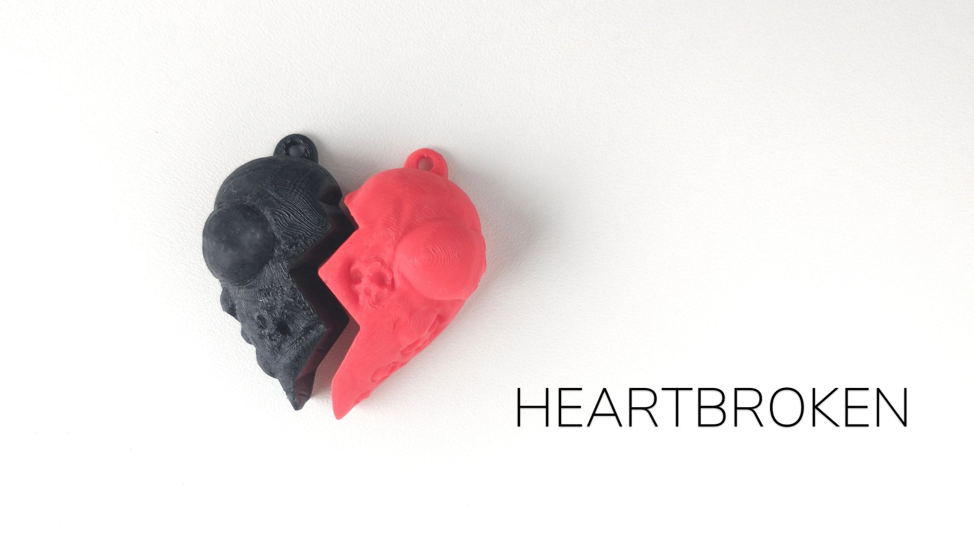 a red and a black heart shaped object on a white background