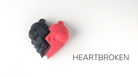 a red and a black heart shaped object on a white background