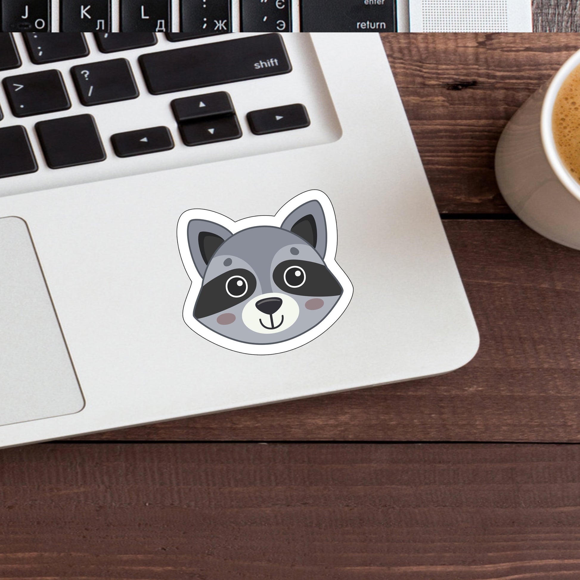 a laptop with a sticker of a raccoon on it