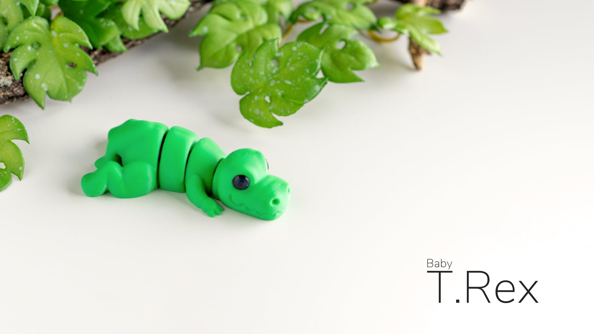 a green toy caterpillar sitting on top of a white surface