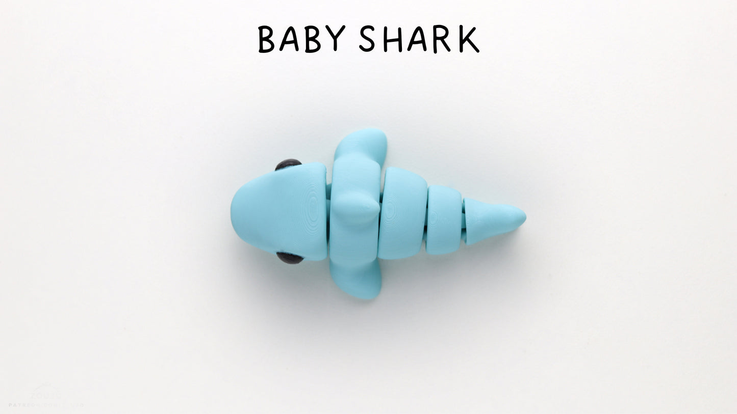 a baby shark toy is shown on a white surface