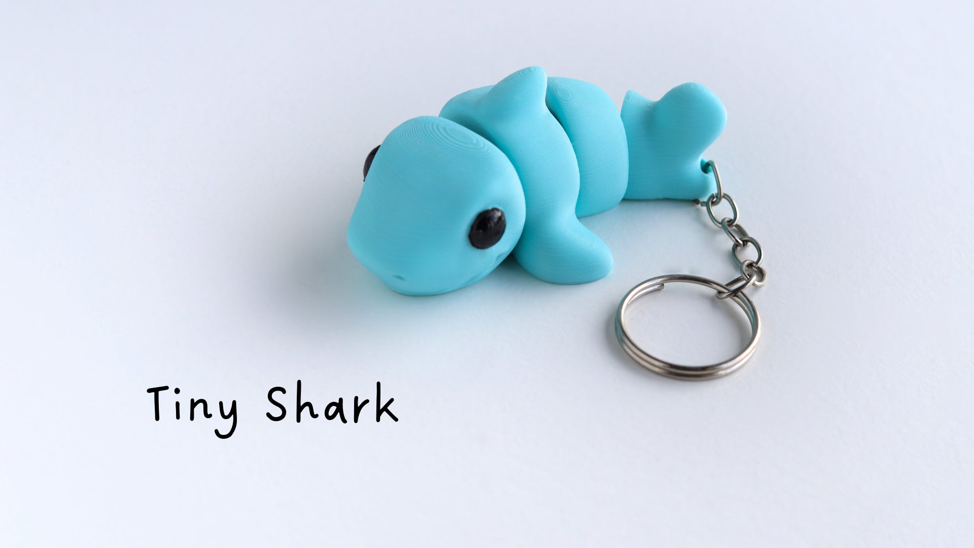 a keychain shaped like a fish laying on a white surface