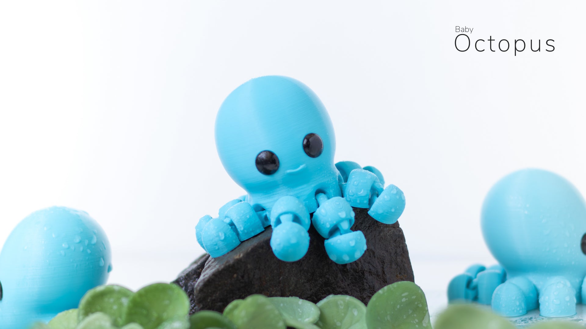 a blue toy octopus sitting on top of a rock