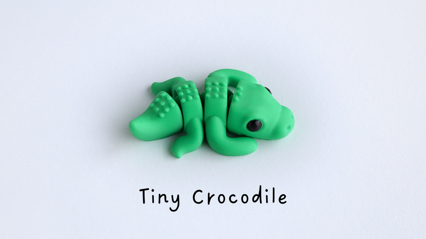 a close up of a toy crocodile on a white surface