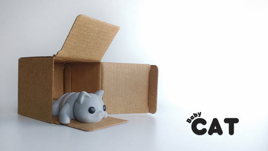 a cat figurine sitting inside of a cardboard box