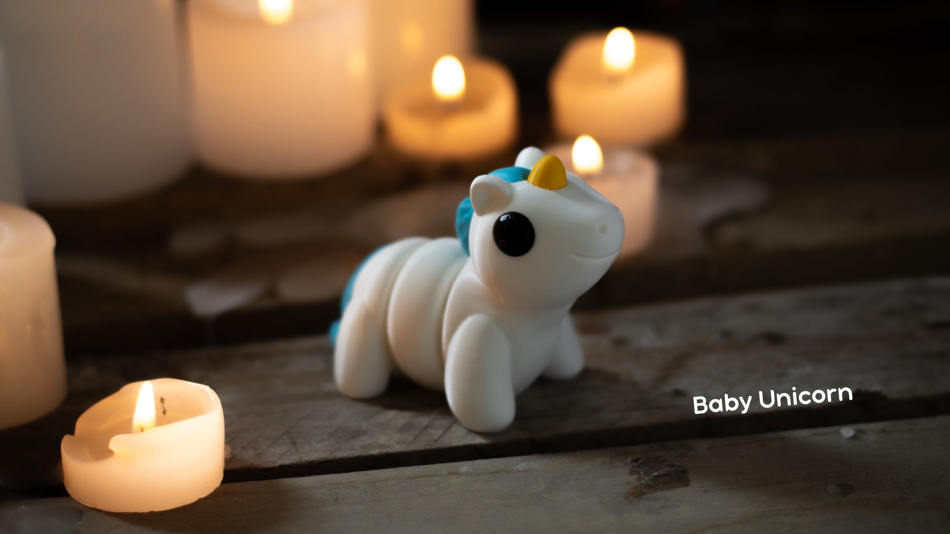 a small toy unicorn sitting next to candles