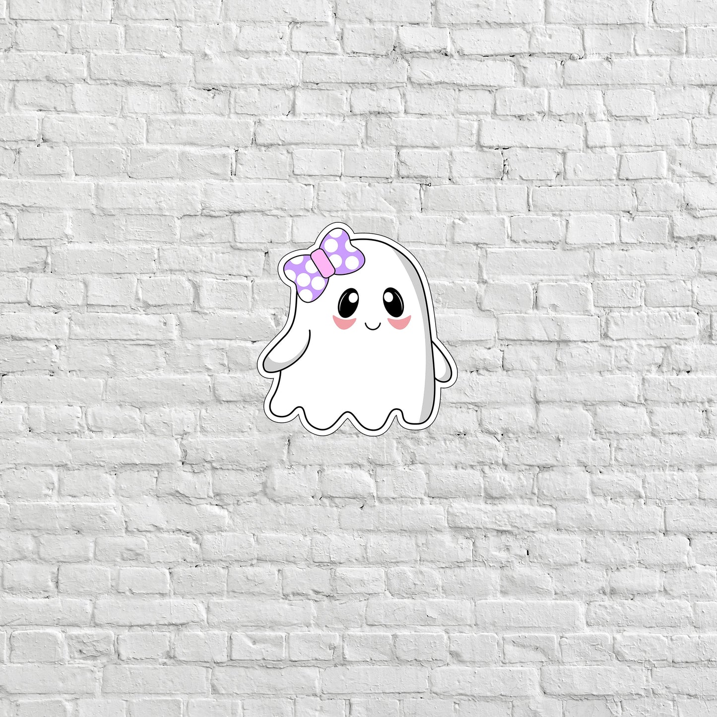 a white brick wall with a sticker of a ghost