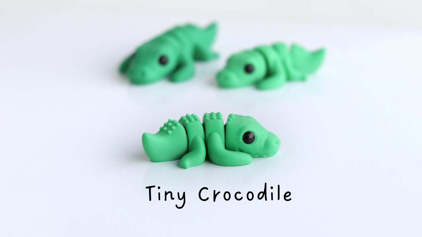 a group of tiny crocodiles sitting on top of a white table