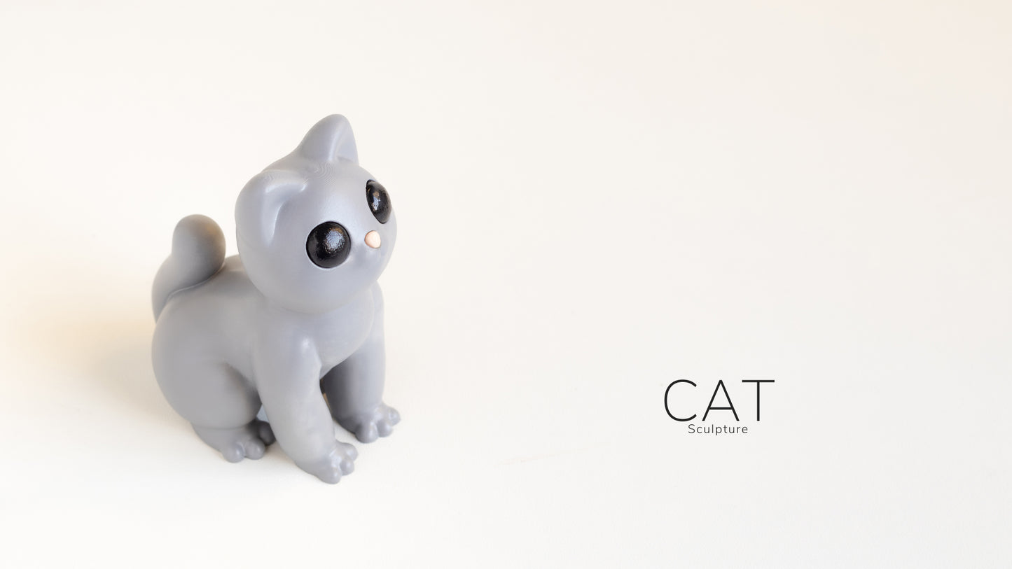 a cat figurine sitting on top of a white surface