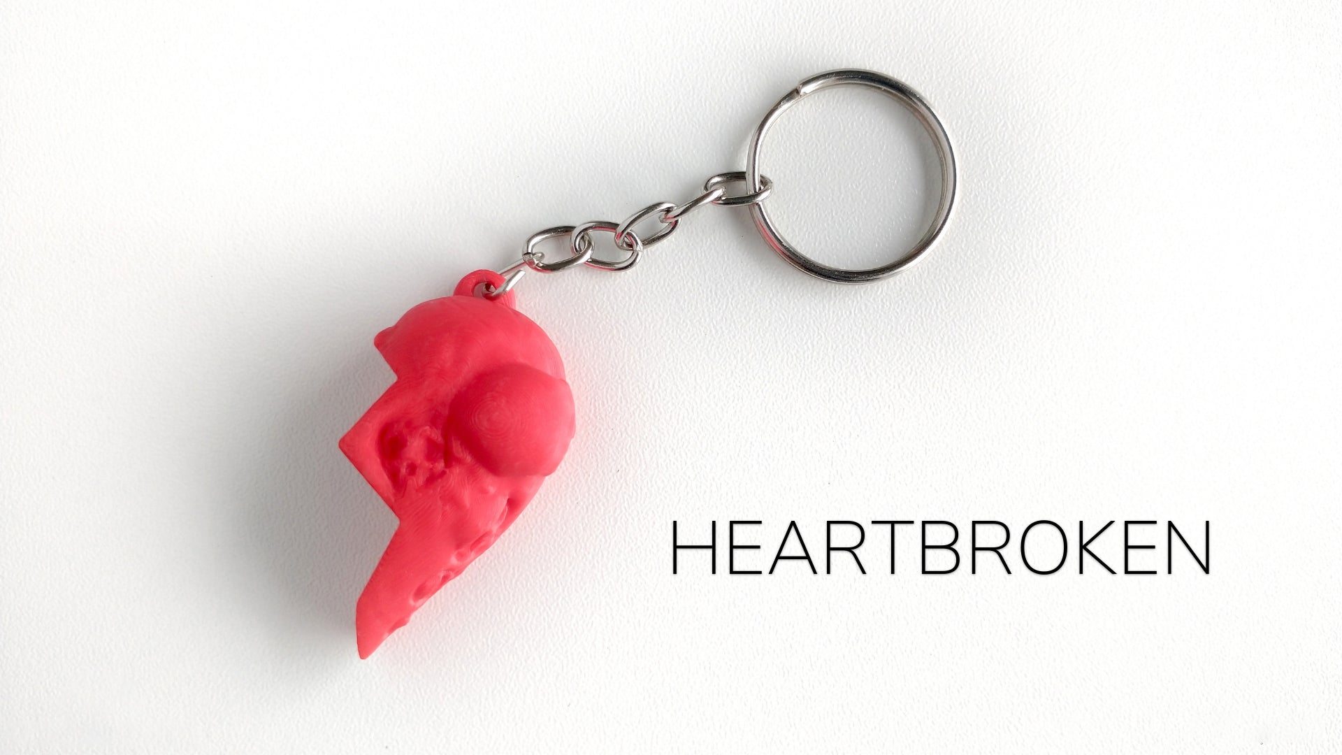 a red keychain with a heart broken on it