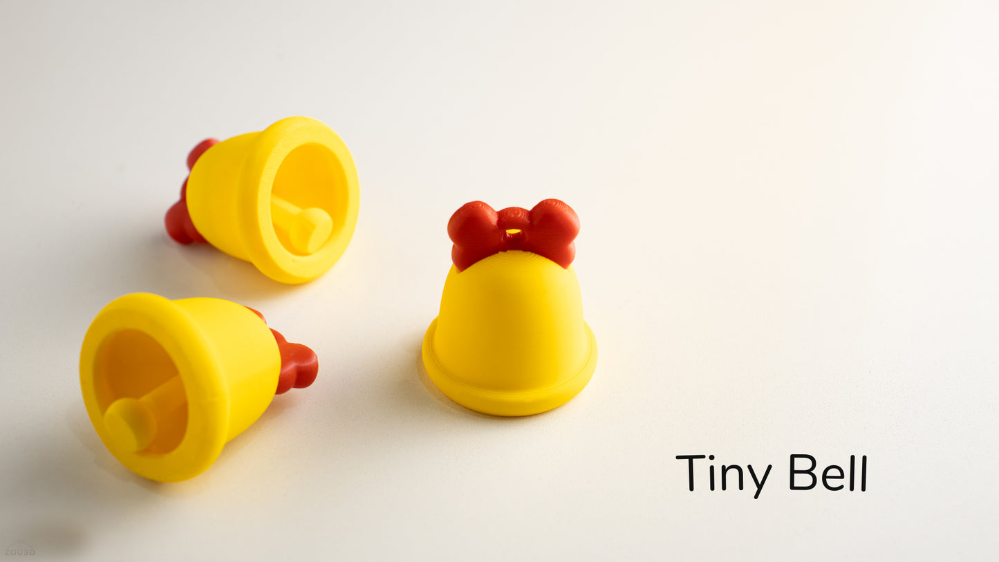 three yellow toy bells with a red bow on them