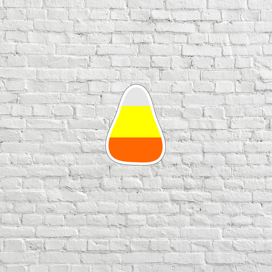 a white brick wall with a yellow and orange cone sticker on it