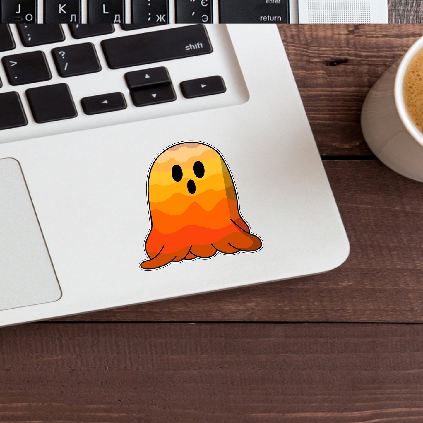 a laptop with a sticker of a ghost on it