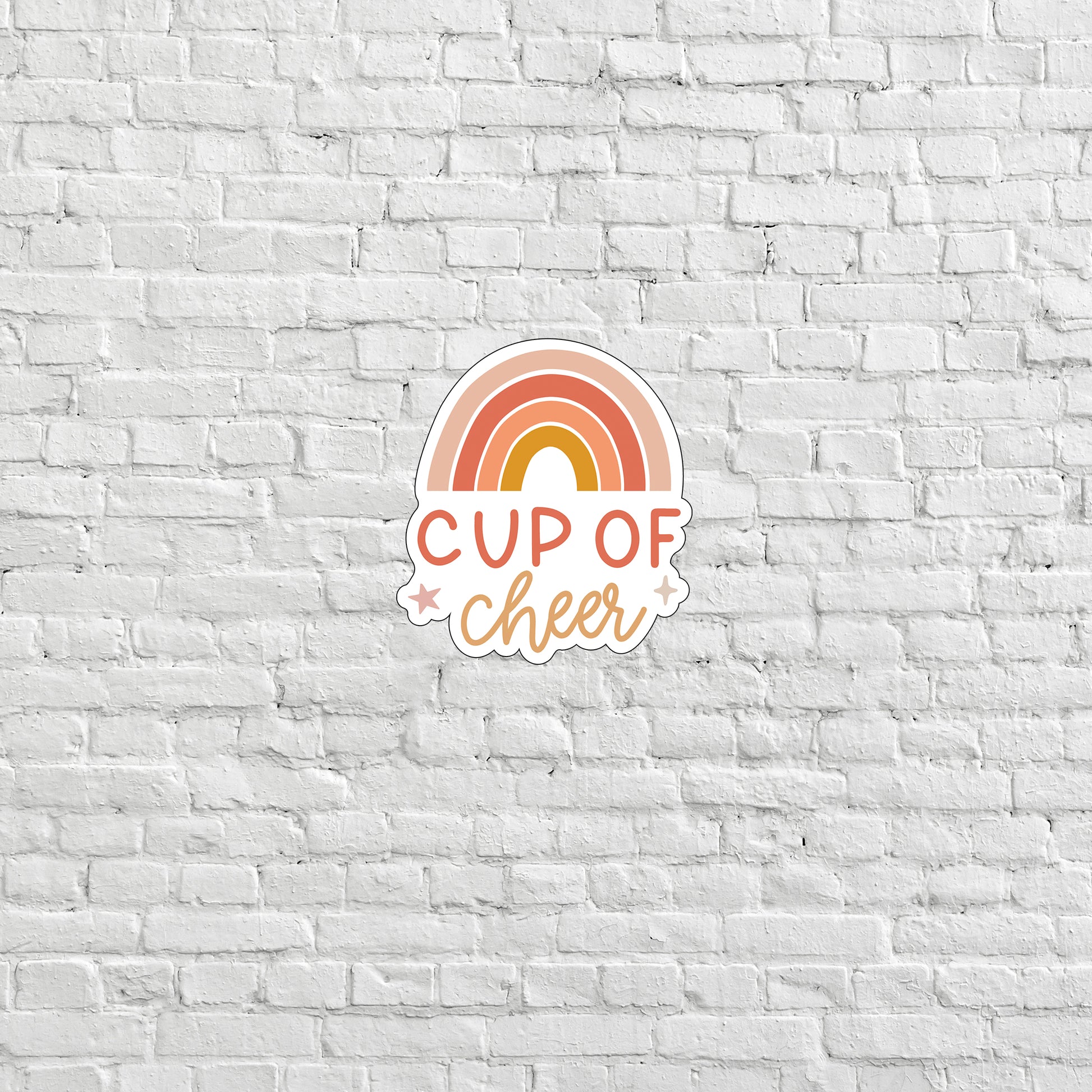 a cup of cheer sticker on a white brick wall