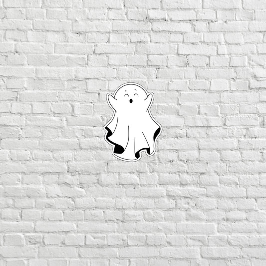 a sticker of a ghost on a white brick wall