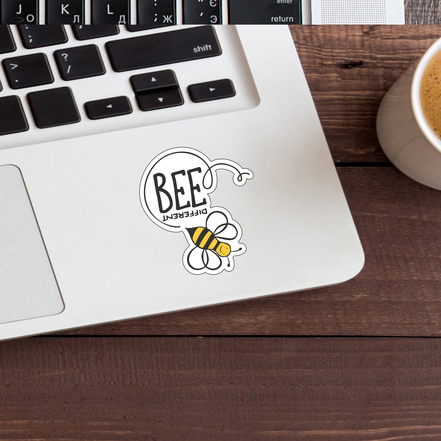 a laptop computer sitting on top of a desk next to a cup of coffee