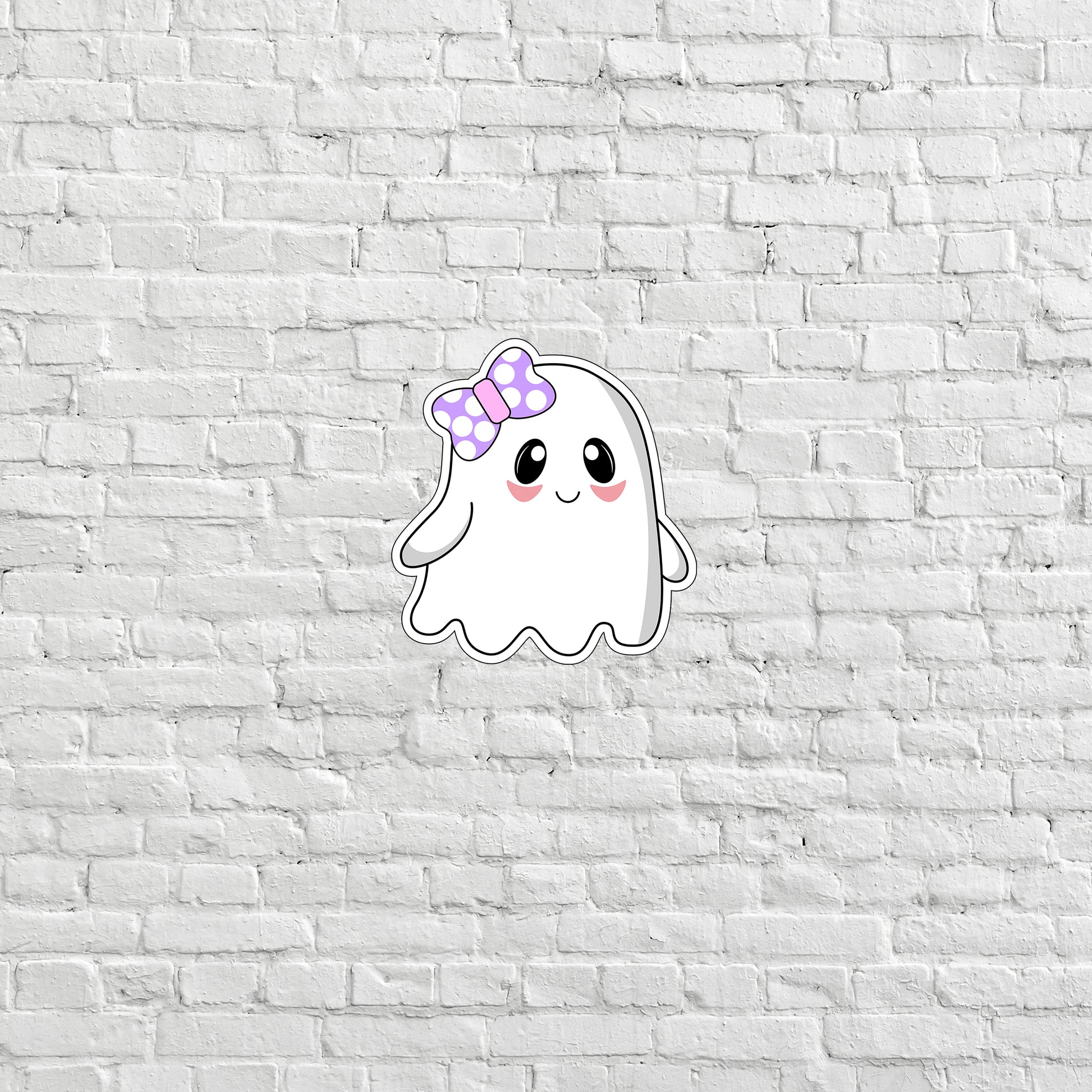 a white brick wall with a sticker of a ghost