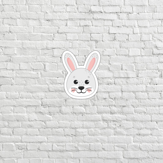 a white brick wall with a rabbit mask on it