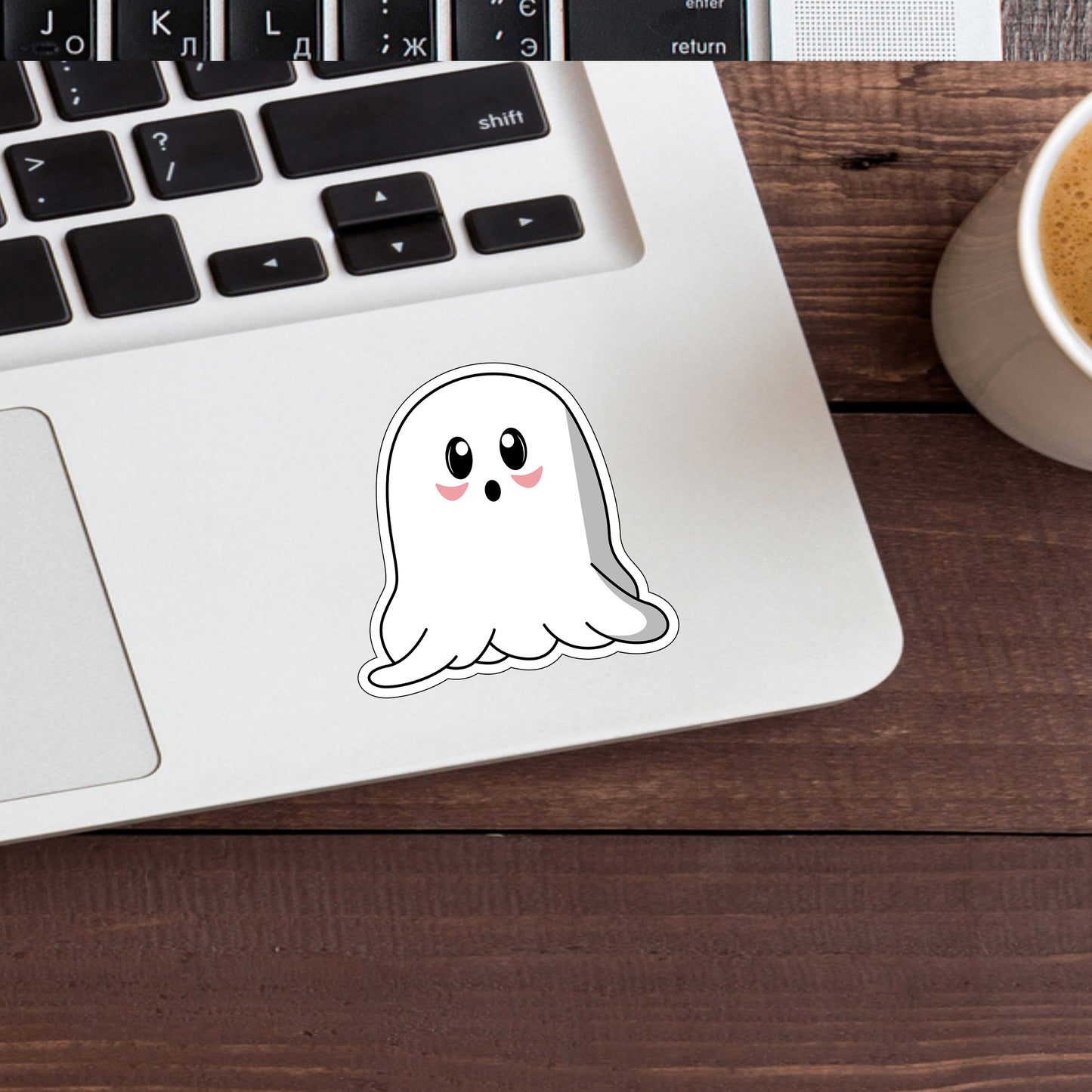 a laptop with a sticker of a ghost on it